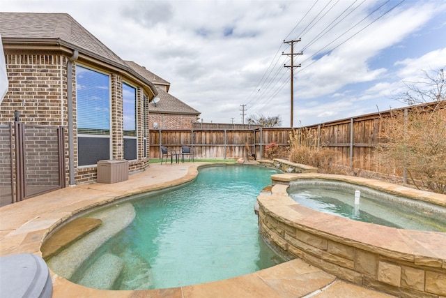 view of pool with a pool with connected hot tub, a fenced backyard, and a patio area