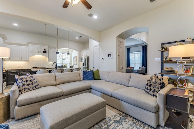 living room featuring arched walkways, recessed lighting, and a ceiling fan