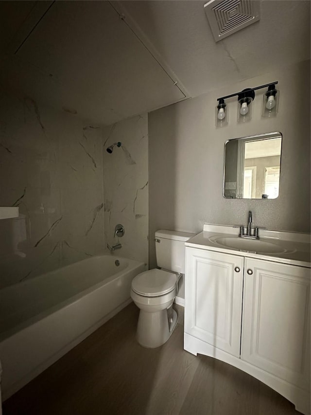 bathroom featuring vanity, wood finished floors, visible vents, shower / bath combination, and toilet