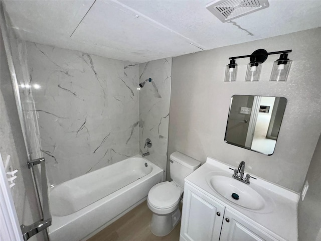 bathroom featuring vanity, wood finished floors, visible vents, tub / shower combination, and toilet