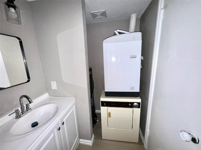 bathroom featuring visible vents, washer / dryer, vanity, and baseboards