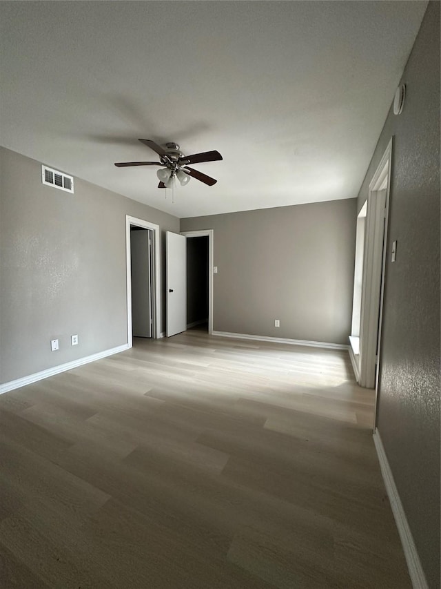 unfurnished room with visible vents, baseboards, ceiling fan, and light wood finished floors