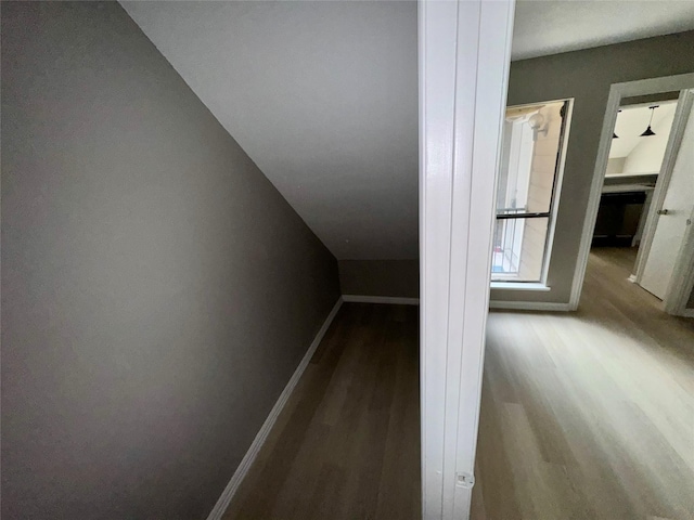 bonus room featuring baseboards, wood finished floors, and vaulted ceiling