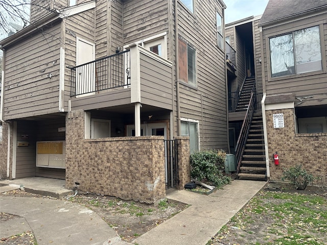 view of side of home featuring a balcony and stairway