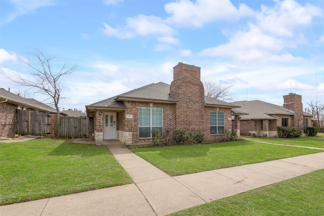 view of front of property featuring a gate, fence, roof with shingles, a front yard, and brick siding