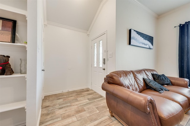 entryway with light wood-style flooring, crown molding, baseboards, and lofted ceiling