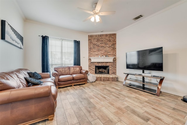 living room with visible vents, light wood-style flooring, crown molding, and ceiling fan