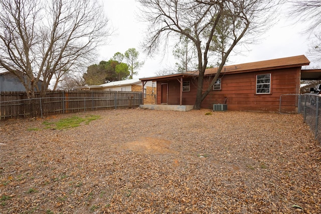 view of yard with an attached carport, cooling unit, and a fenced backyard