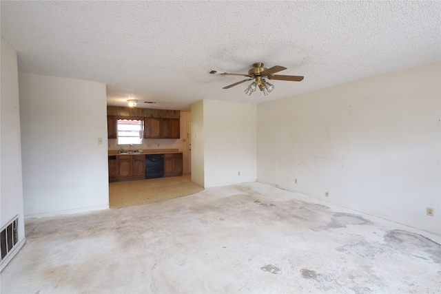 unfurnished living room with a textured ceiling, a ceiling fan, visible vents, and a sink