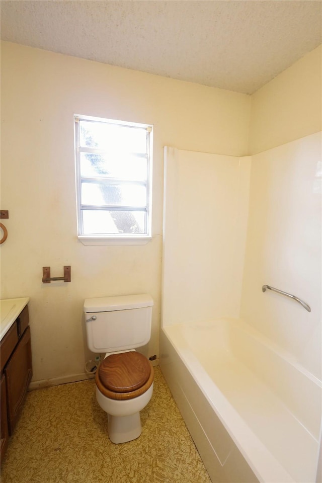 full bath featuring a textured ceiling, toilet, and vanity