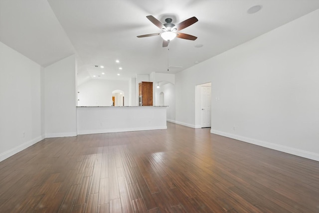 unfurnished living room featuring a ceiling fan, dark wood-style floors, recessed lighting, arched walkways, and baseboards