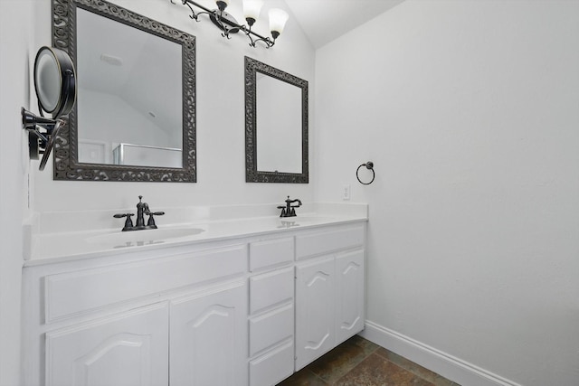 full bathroom featuring a sink, baseboards, double vanity, and vaulted ceiling