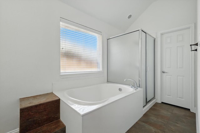 bathroom with a garden tub, a stall shower, and lofted ceiling