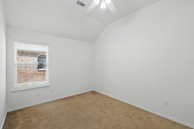 spare room with visible vents, baseboards, vaulted ceiling, carpet floors, and a ceiling fan