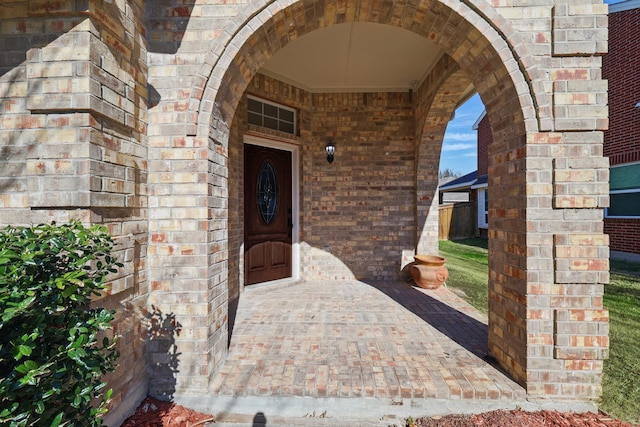 view of exterior entry featuring stone siding and brick siding