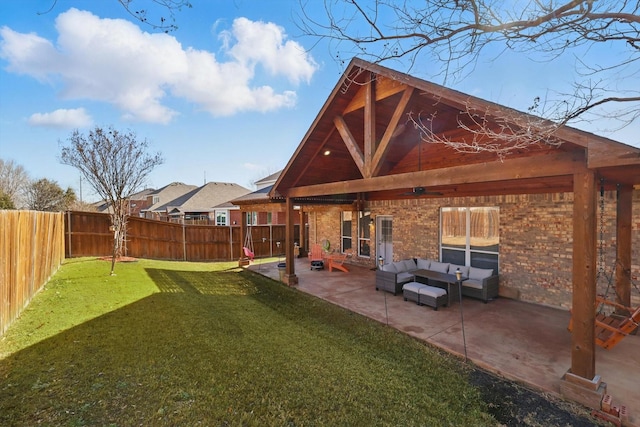 rear view of property featuring a yard, a fenced backyard, a patio area, brick siding, and an outdoor hangout area