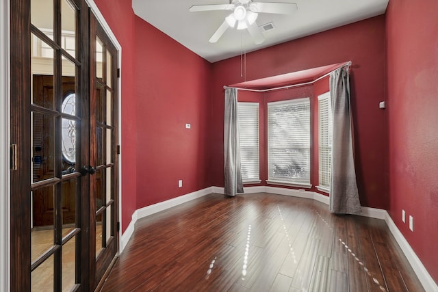 unfurnished room featuring visible vents, baseboards, a ceiling fan, and wood finished floors