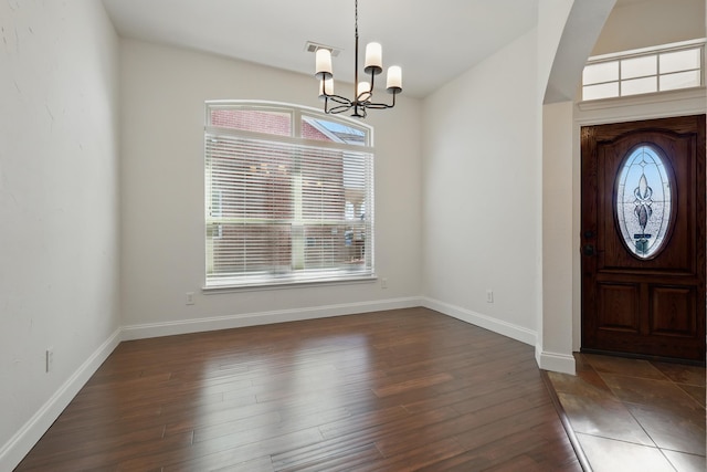 foyer entrance with visible vents, wood finished floors, baseboards, and a chandelier