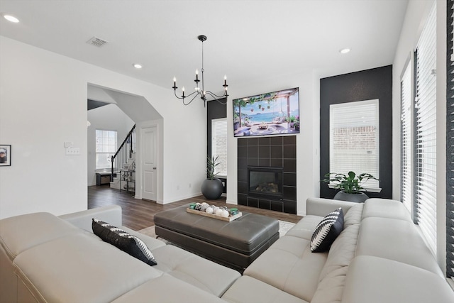 living area with stairway, wood finished floors, visible vents, an inviting chandelier, and recessed lighting