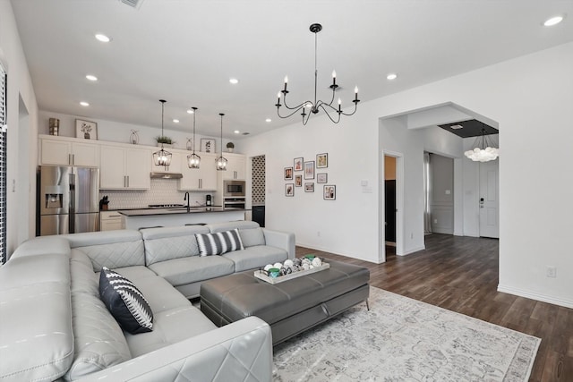 living area with visible vents, baseboards, an inviting chandelier, recessed lighting, and dark wood-style flooring