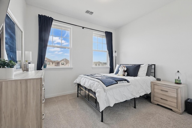 bedroom featuring visible vents, baseboards, and light colored carpet