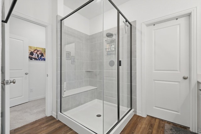 full bathroom featuring wood finished floors and a stall shower