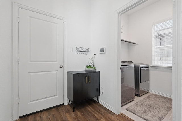 laundry room featuring laundry area, dark wood-style floors, baseboards, and washer and clothes dryer