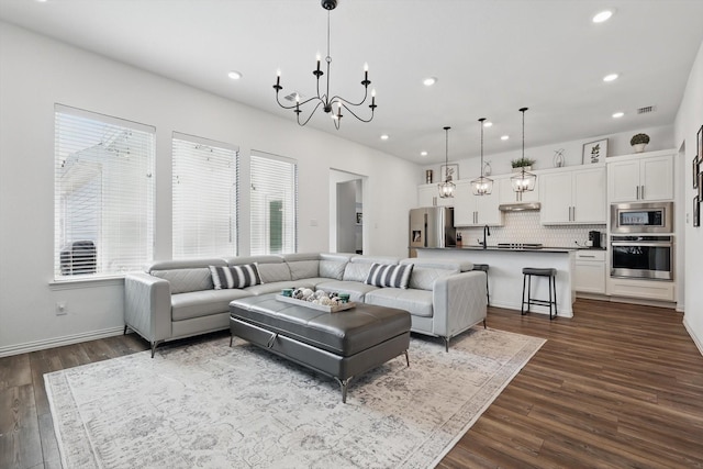 living area featuring dark wood finished floors, a notable chandelier, recessed lighting, and visible vents