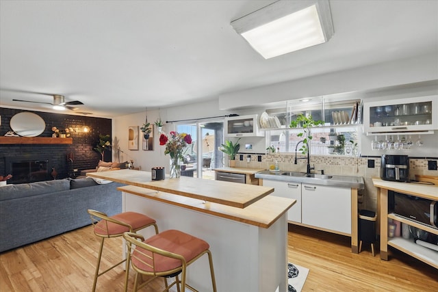 kitchen with a sink, light wood-style floors, a breakfast bar area, and butcher block counters