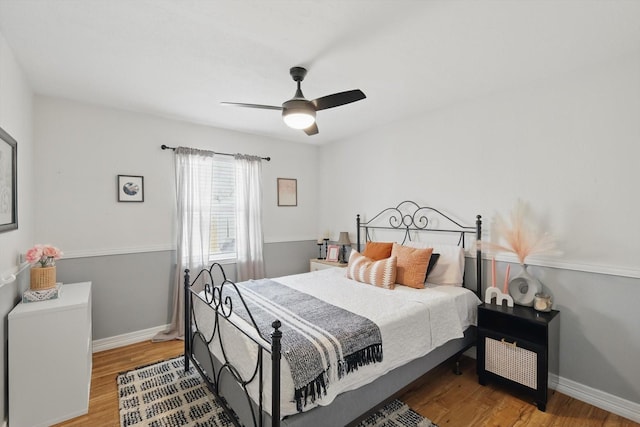 bedroom featuring ceiling fan, baseboards, and wood finished floors