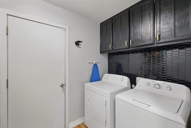 laundry area with cabinet space, separate washer and dryer, and a textured ceiling