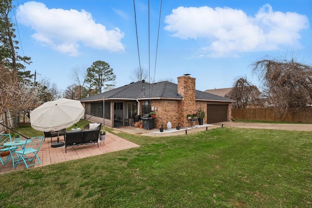 back of house with fence, a sunroom, concrete driveway, a garage, and a lawn