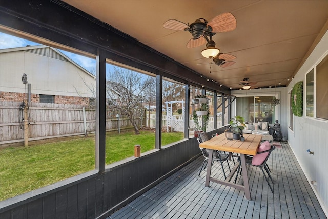 sunroom / solarium featuring a ceiling fan