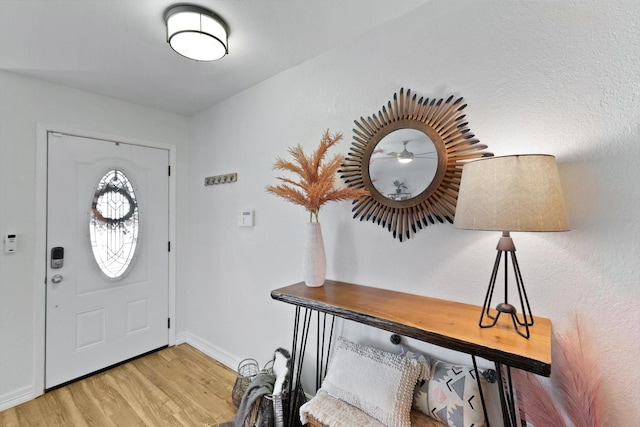 foyer entrance with baseboards and light wood finished floors