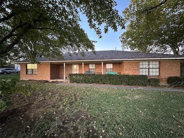 single story home featuring brick siding and a front yard