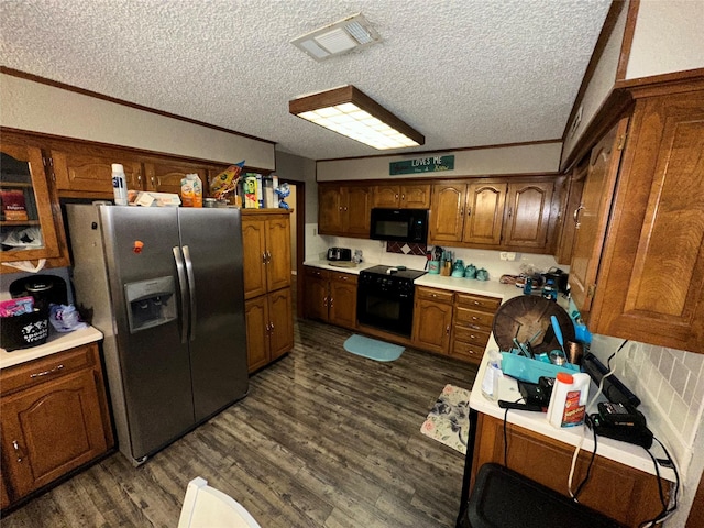 kitchen with visible vents, dark wood finished floors, light countertops, brown cabinets, and black appliances