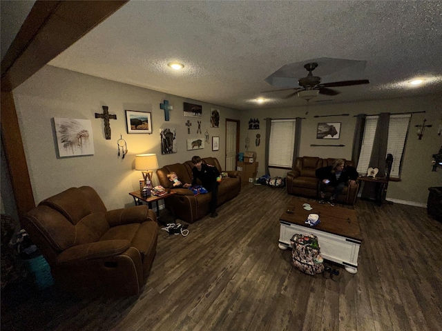 living room with a textured ceiling, ceiling fan, and wood finished floors