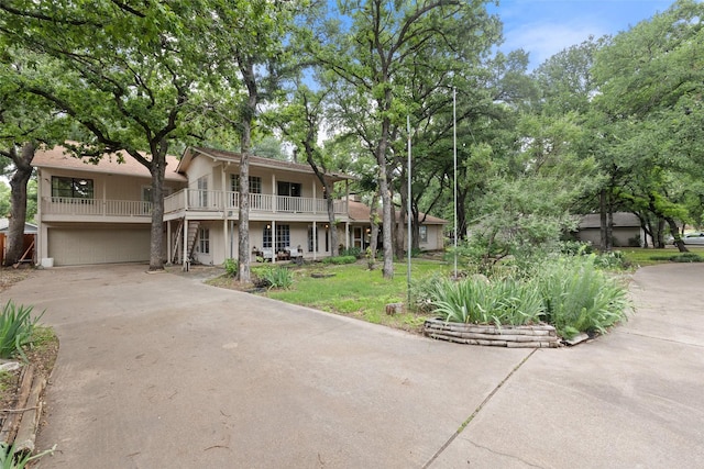 view of front of home with stucco siding, a front lawn, concrete driveway, and a garage