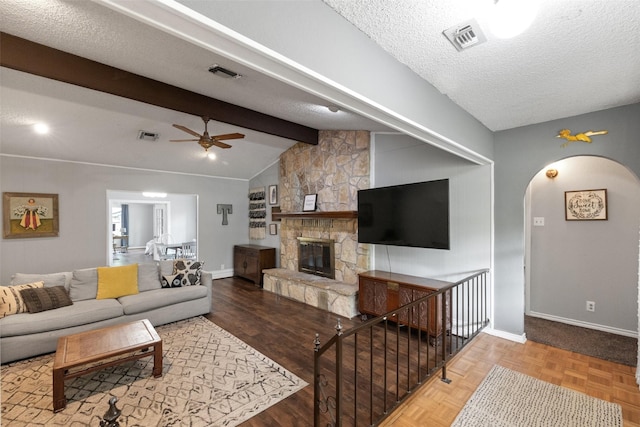 living room featuring visible vents, a textured ceiling, lofted ceiling with beams, and a ceiling fan