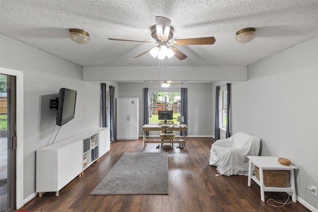 interior space featuring wood finished floors, a ceiling fan, baseboards, and a textured ceiling