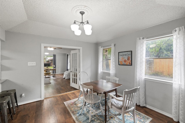 dining space with baseboards, wood-type flooring, plenty of natural light, and an inviting chandelier