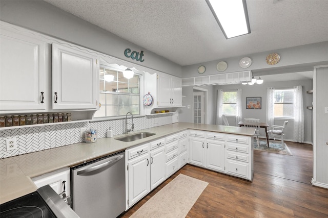 kitchen with stainless steel dishwasher, light countertops, a peninsula, and a sink