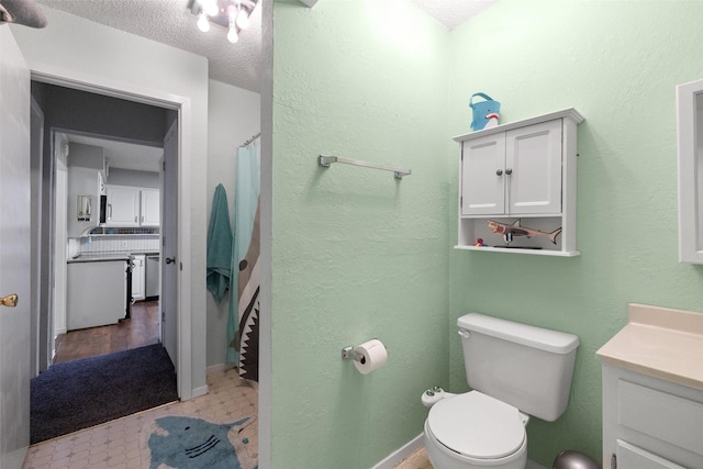 full bath featuring toilet, a textured ceiling, vanity, and baseboards