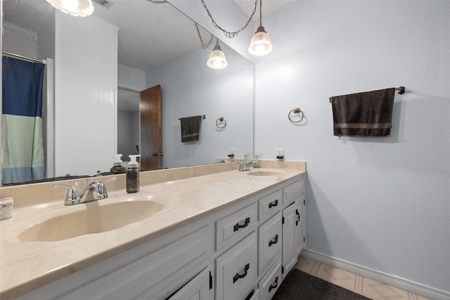 bathroom featuring double vanity, baseboards, and a sink