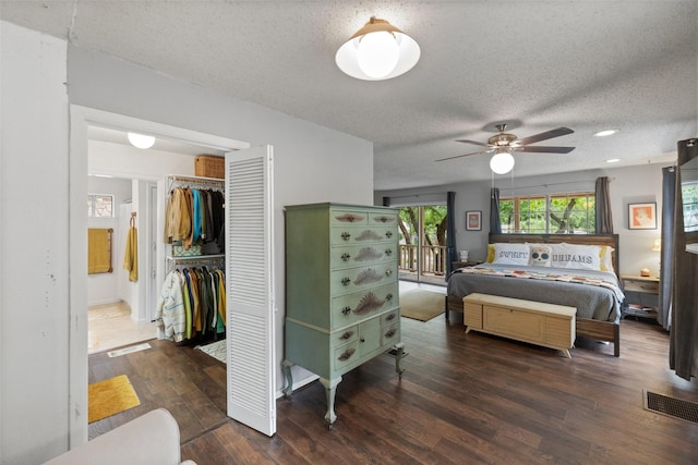 bedroom featuring visible vents, a ceiling fan, a textured ceiling, wood finished floors, and a closet