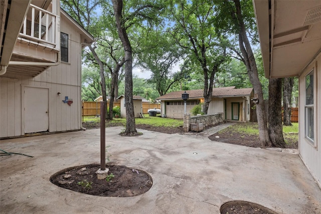 view of patio with a storage shed, an outbuilding, and fence