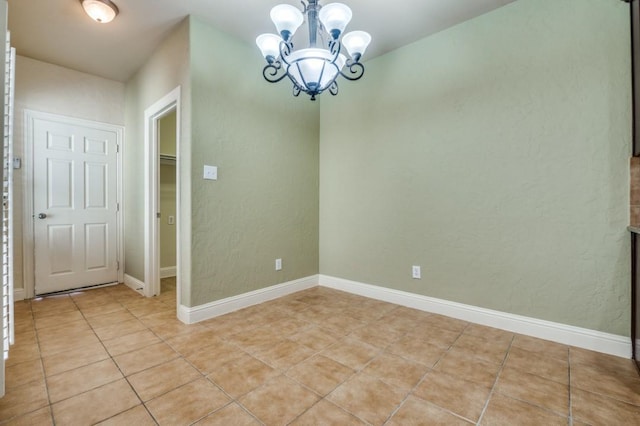 unfurnished dining area with light tile patterned floors, a notable chandelier, and baseboards