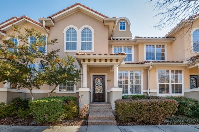 mediterranean / spanish-style house featuring a tiled roof and stucco siding