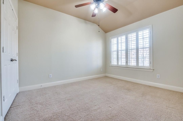 carpeted spare room with baseboards, lofted ceiling, and a ceiling fan