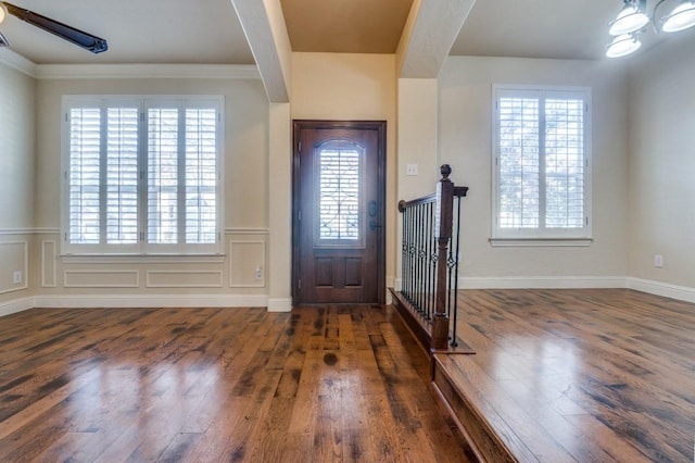 foyer entrance with a decorative wall and wood finished floors